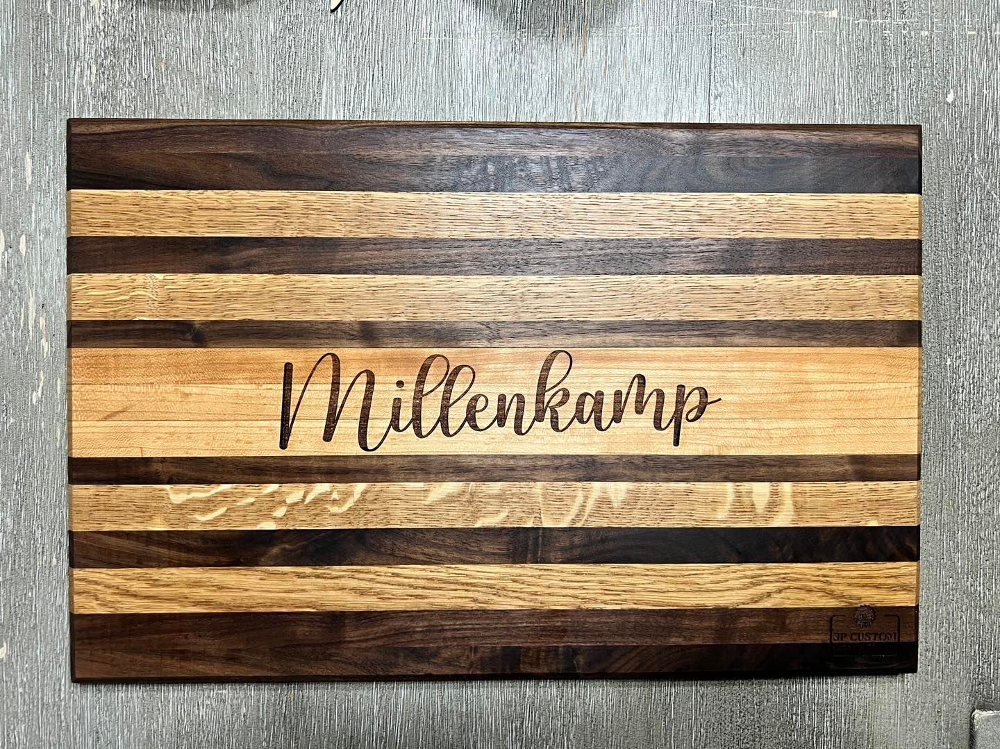Wooden cutting board with alternating dark and light wood stripes, name 
