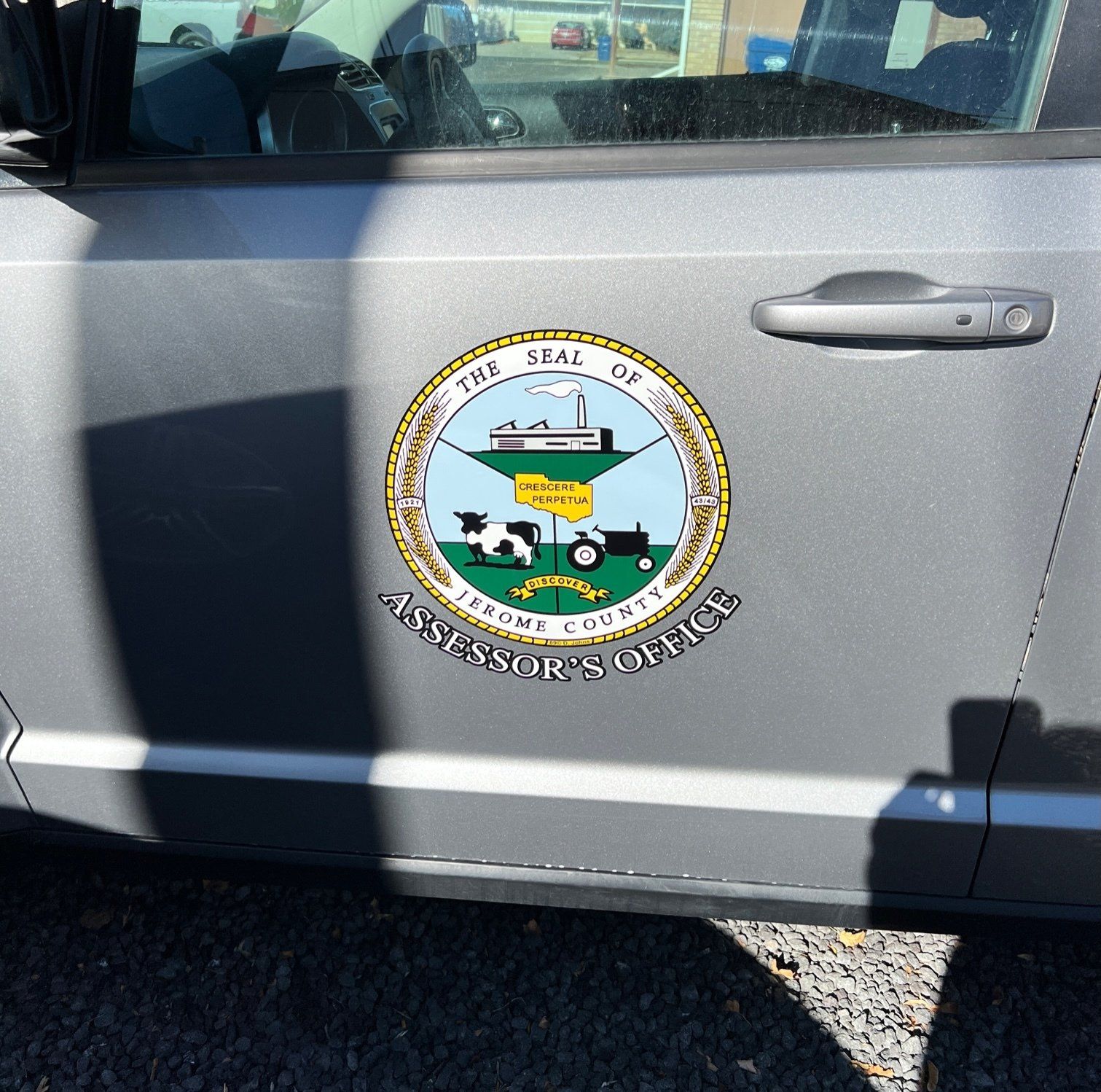Gray vehicle door with Jenkins County Assessor’s Office seal. The seal has blue, yellow, and black graphics.