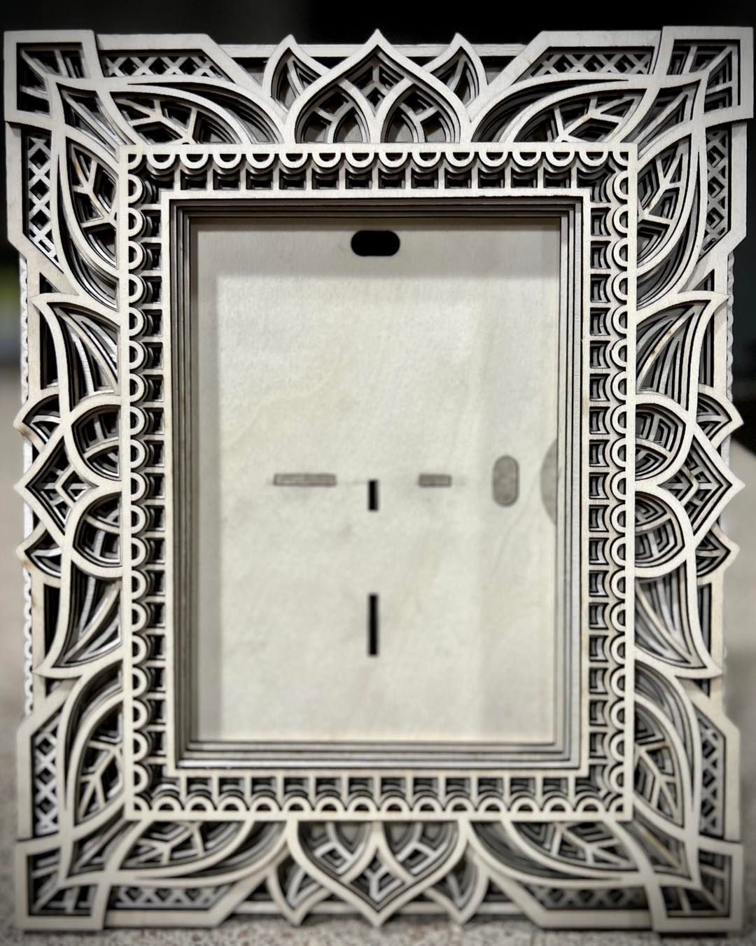 Ornate, multi-layered, laser-cut picture frame. White and gray layers with intricate geometric and floral designs.