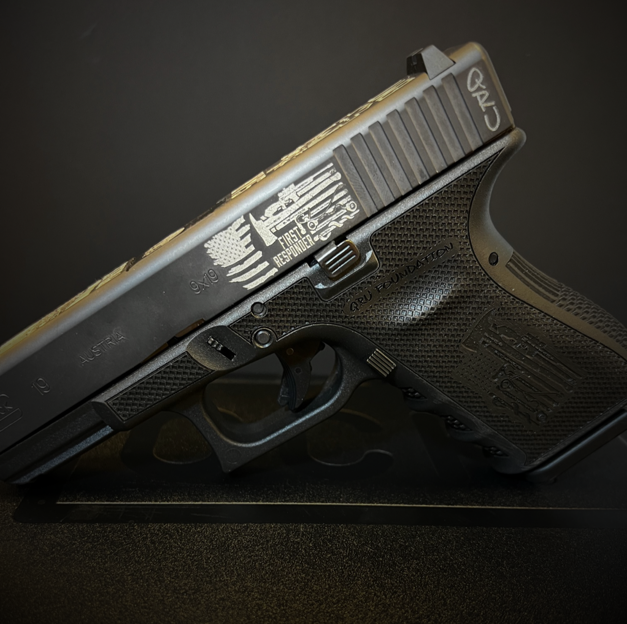 Black handgun on a dark surface, angled side view with textured grip and visible slide details