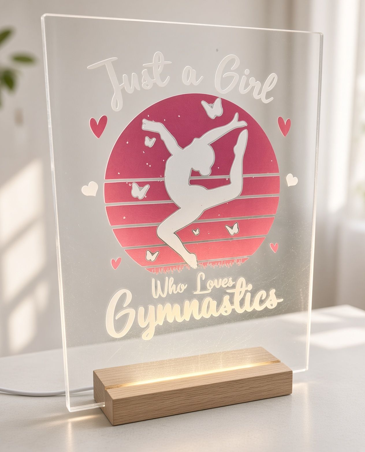 A clear acrylic plaque on a wooden stand with a gymnast silhouette and the words “Just a Girl Who Is Gymnastics.”