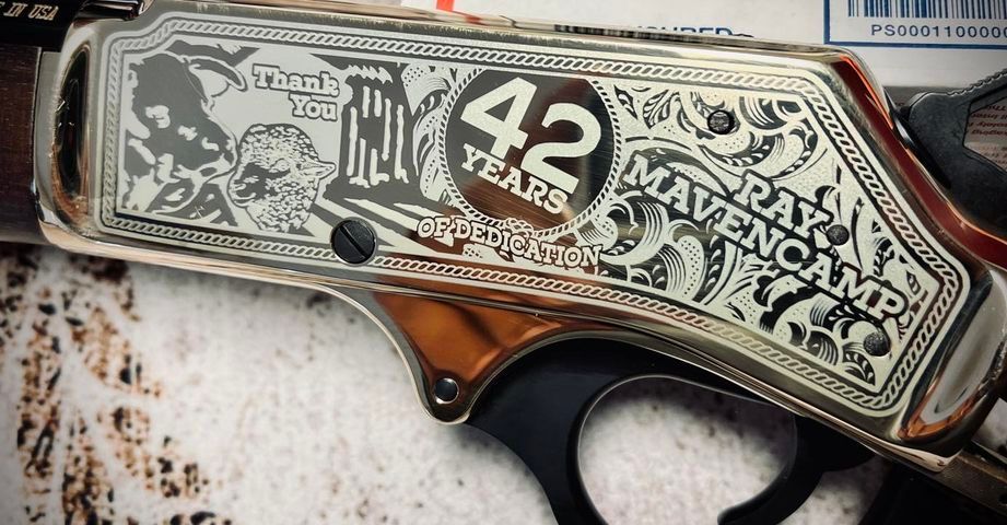 Engraved metal gun receiver: “42 Years” text, artwork, “Ray Mavencamp” name.