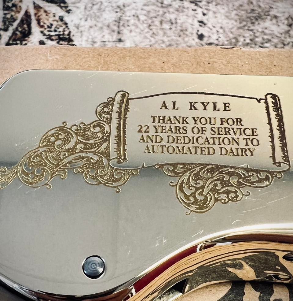 Plaque honoring Al Kyle for 22 years of service to Automated Dairy. Beige and gold scrollwork.