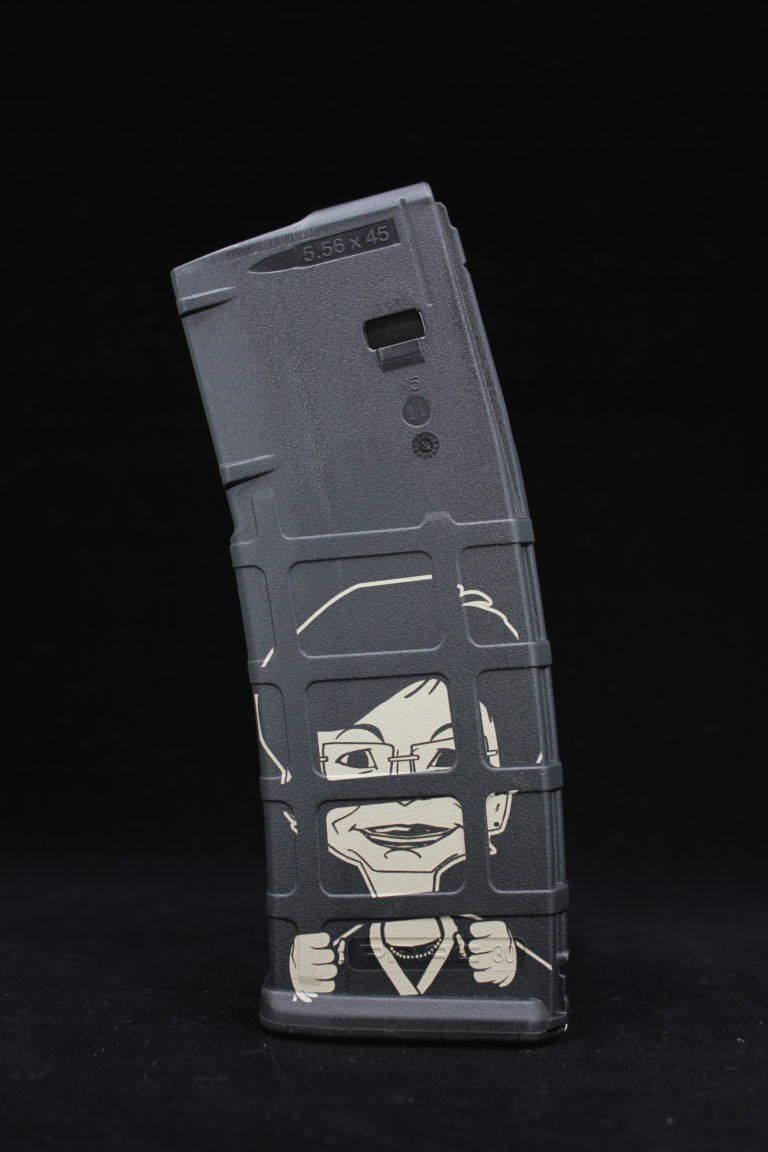 Black tactical device with a stencil-style face graphic on a dark background