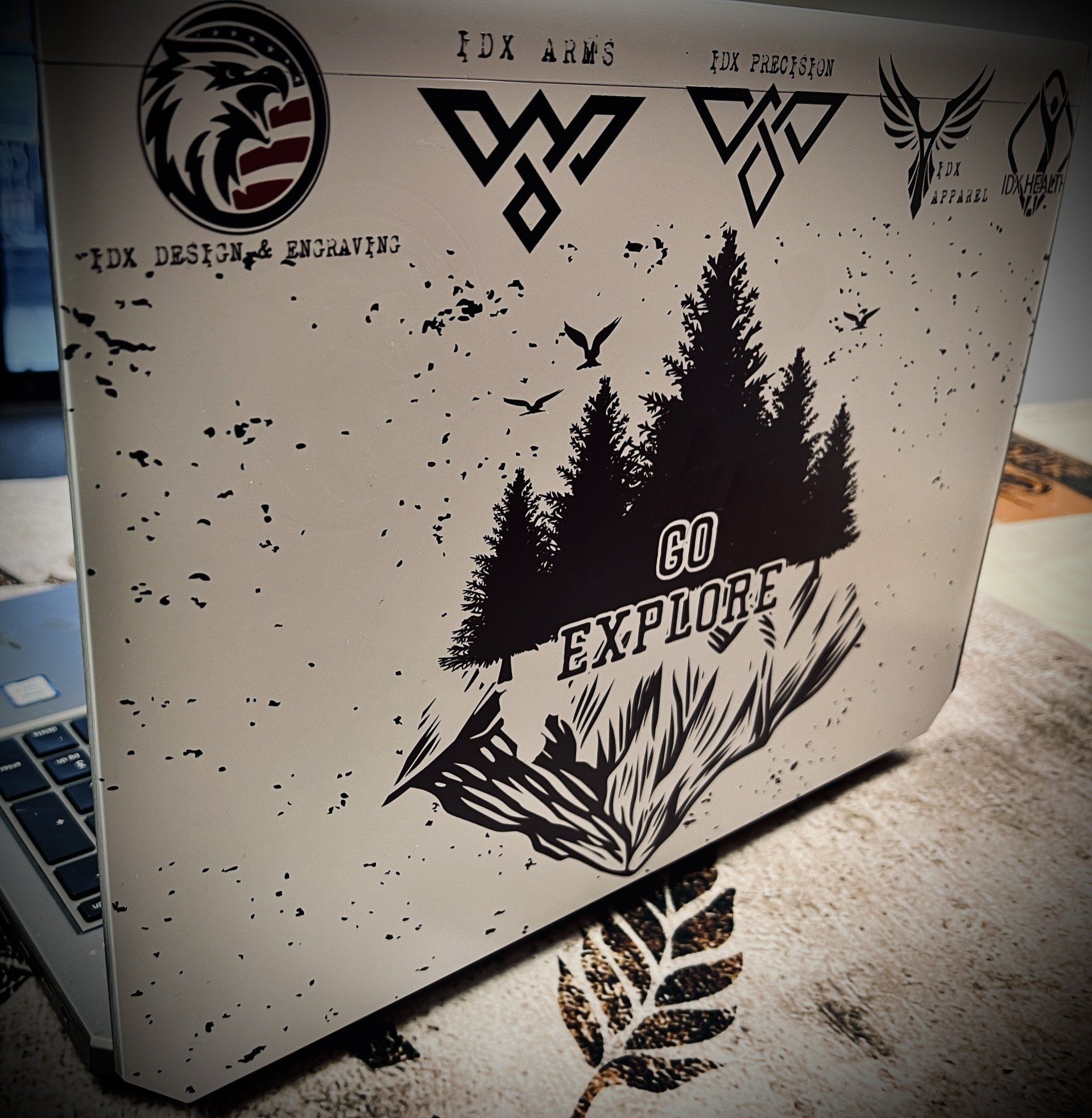 Laptop with stickers: eagle emblem, woodland scene with 