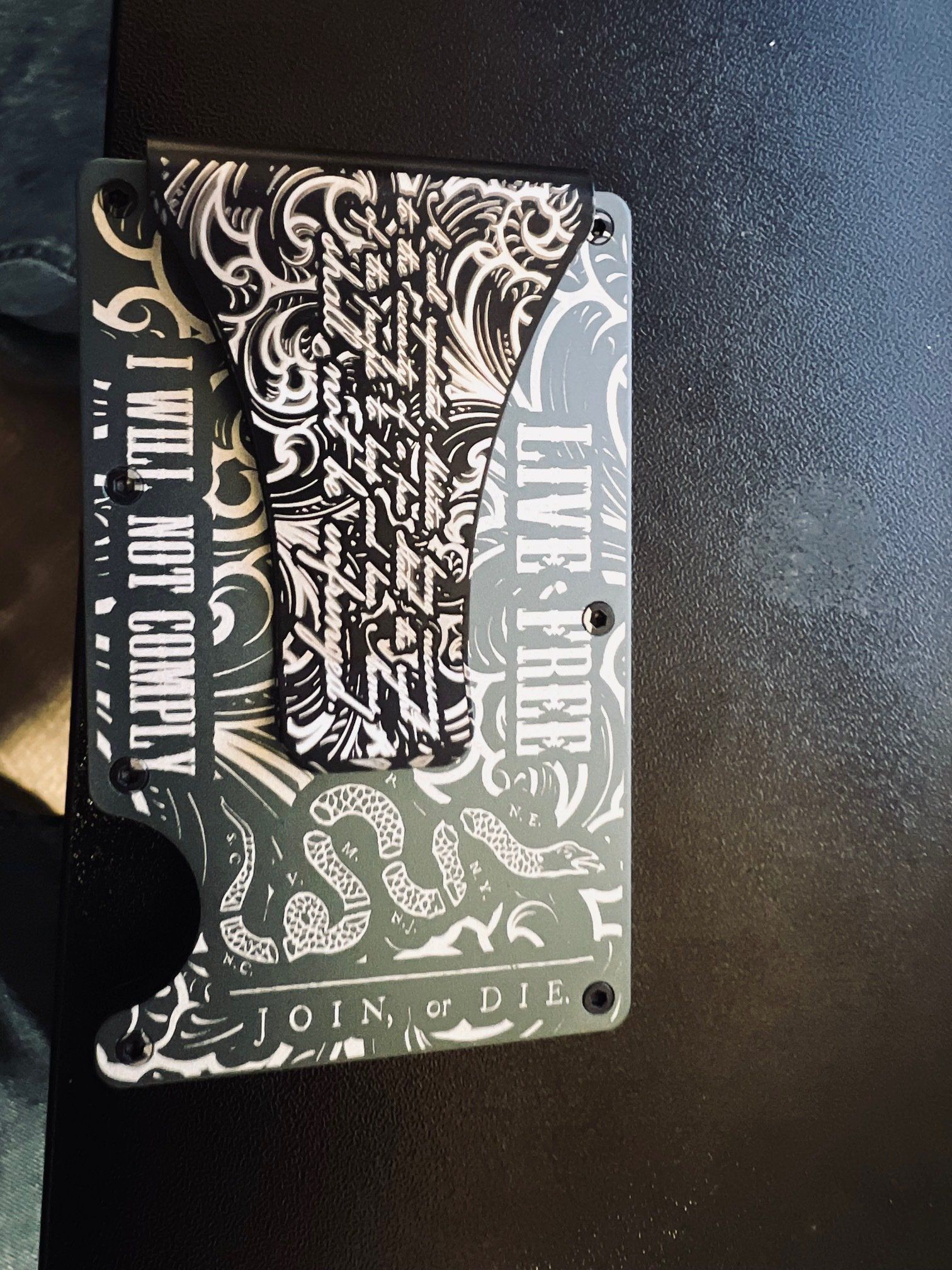 Black-and-white graphic city pass card with ornate patterns and the words “I’M NOT CUTE” on a dark textured surface