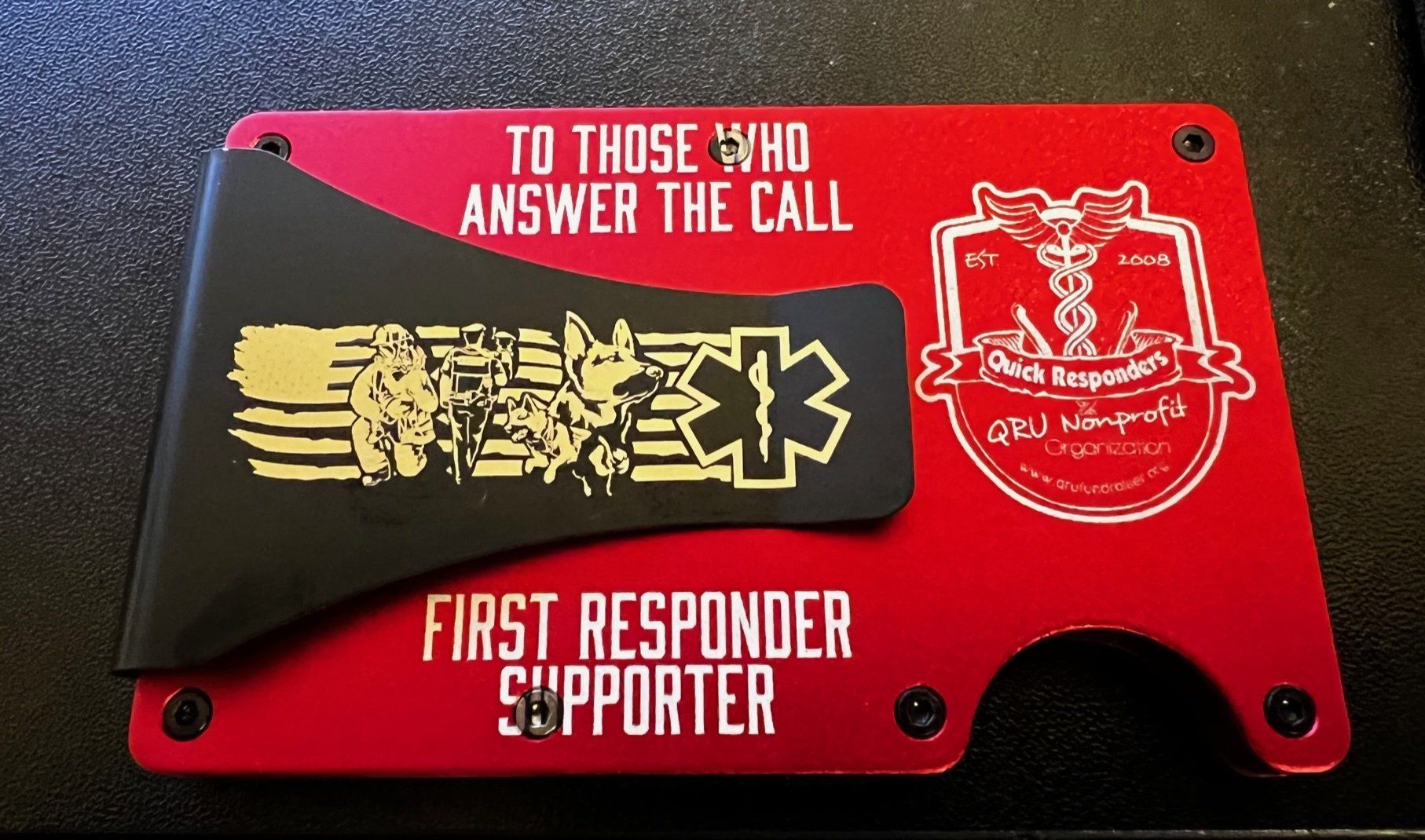 Red and black first responder plaque with a gold emblem and white text: “To those who answer the call.”