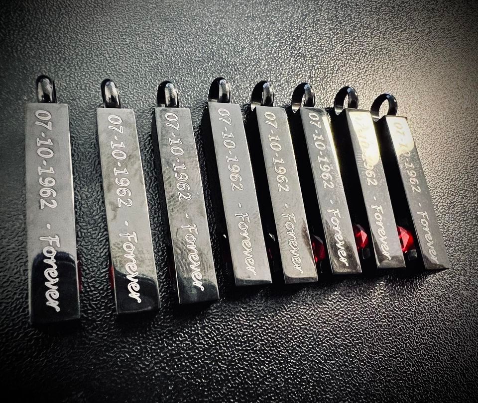 Seven black rectangular pendants engraved with 