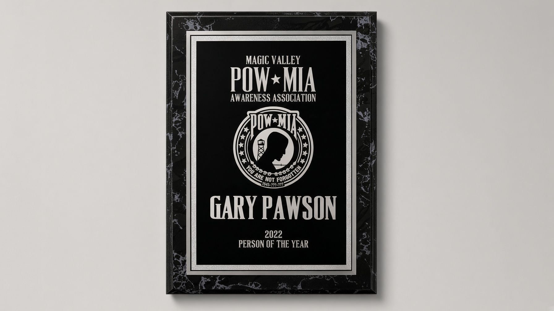 Plaque honoring Gary Pawson, POW*MIA recognition award, black with gold lettering and emblem.