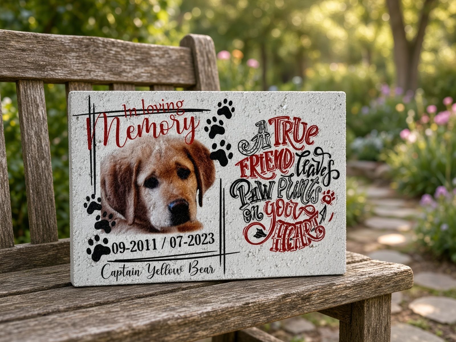 Memorial plaque with a brown dog portrait, paw prints, and red script on a speckled gray stone background