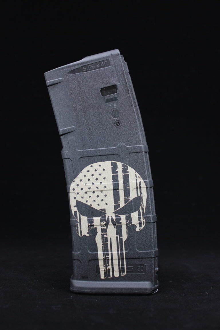 Black handgun magazine with a white skull logo on a dark background
