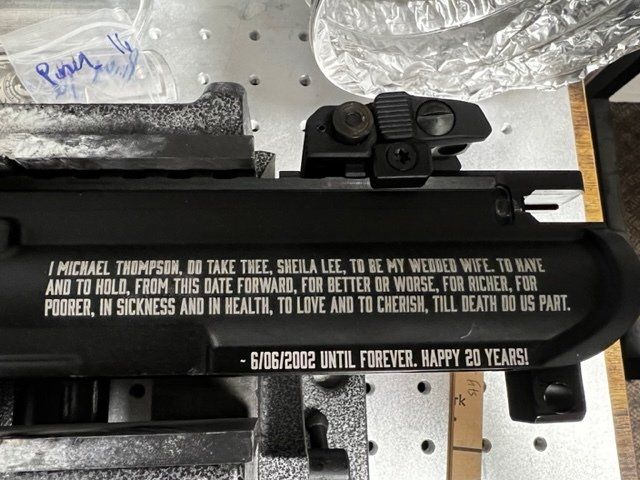 Black rifle upper receiver engraved with wedding vows and anniversary date.