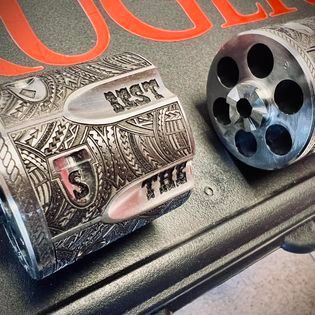Engraved silver gun parts, close up. Text 