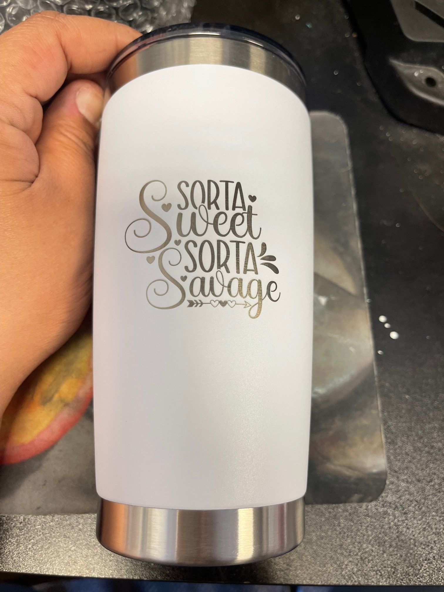 White tumbler with silver ends, held in hand, featuring “Sorta sweet sorta savage” text.