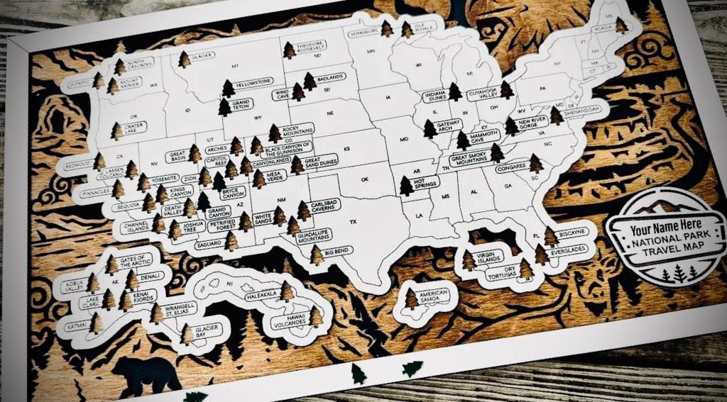 Wooden map of the US with etched state outlines, trees, mountains, and a bear.