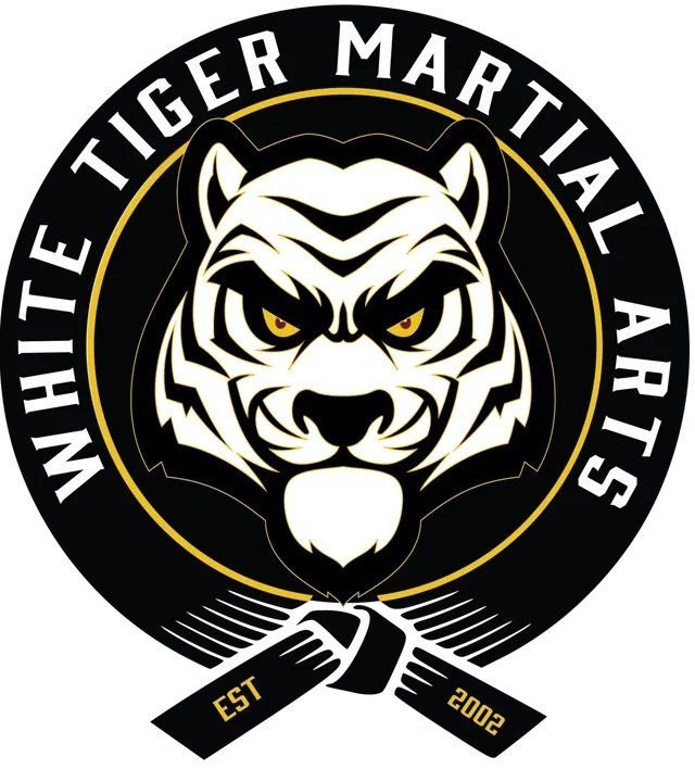 White Tiger Martial Arts circular logo with fierce tiger face, black and white, crossed nunchaku, EST 2002