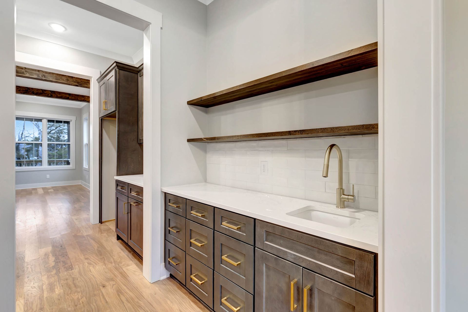 A kitchen with wooden cabinets , a sink , and shelves.