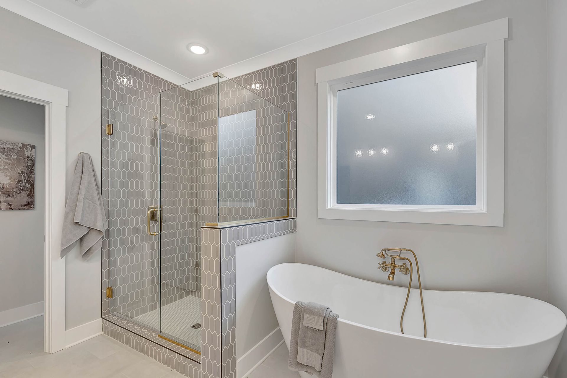 A bathroom with a tub , shower , and window.