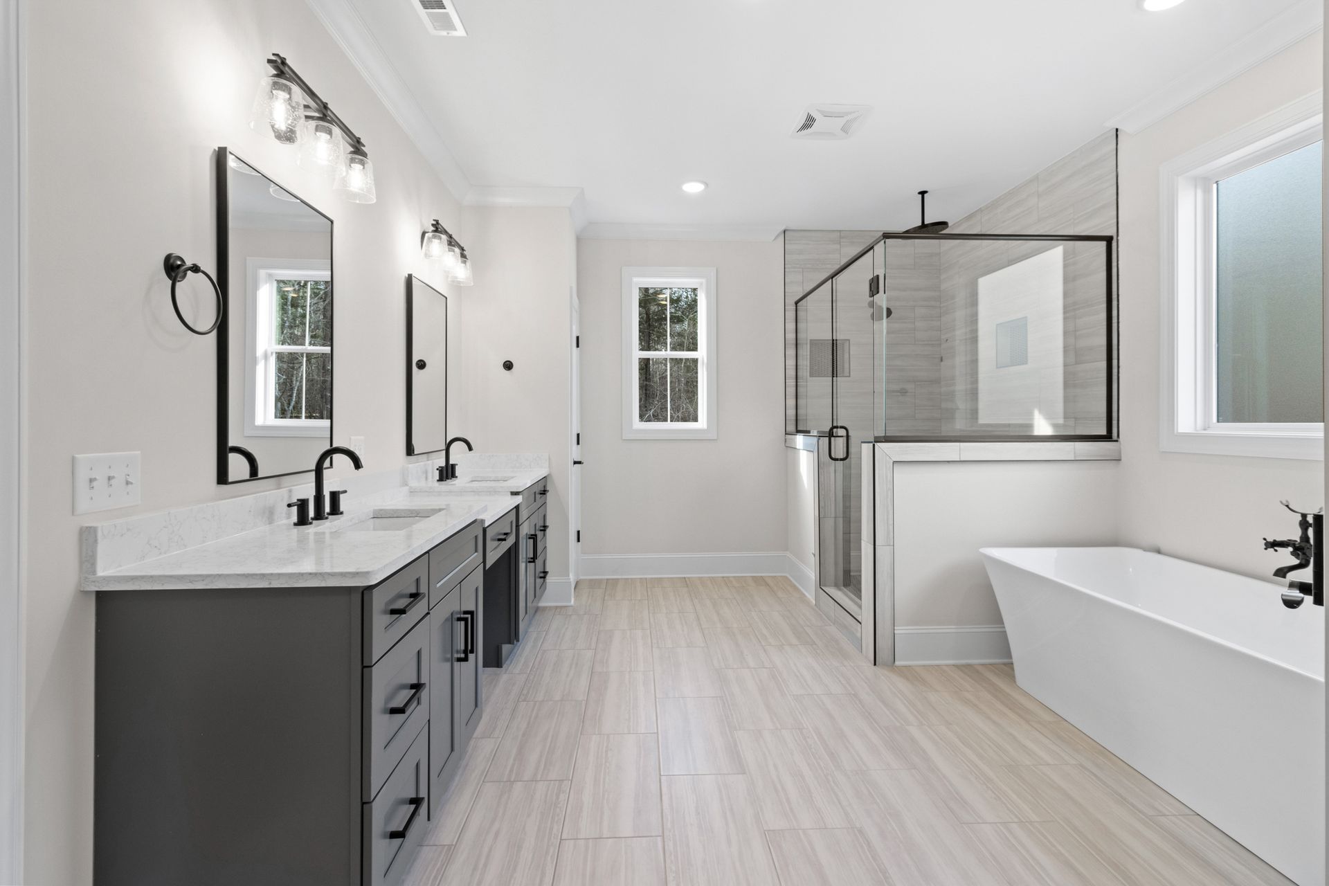 a bathroom with two sinks , a tub , and a walk in shower .