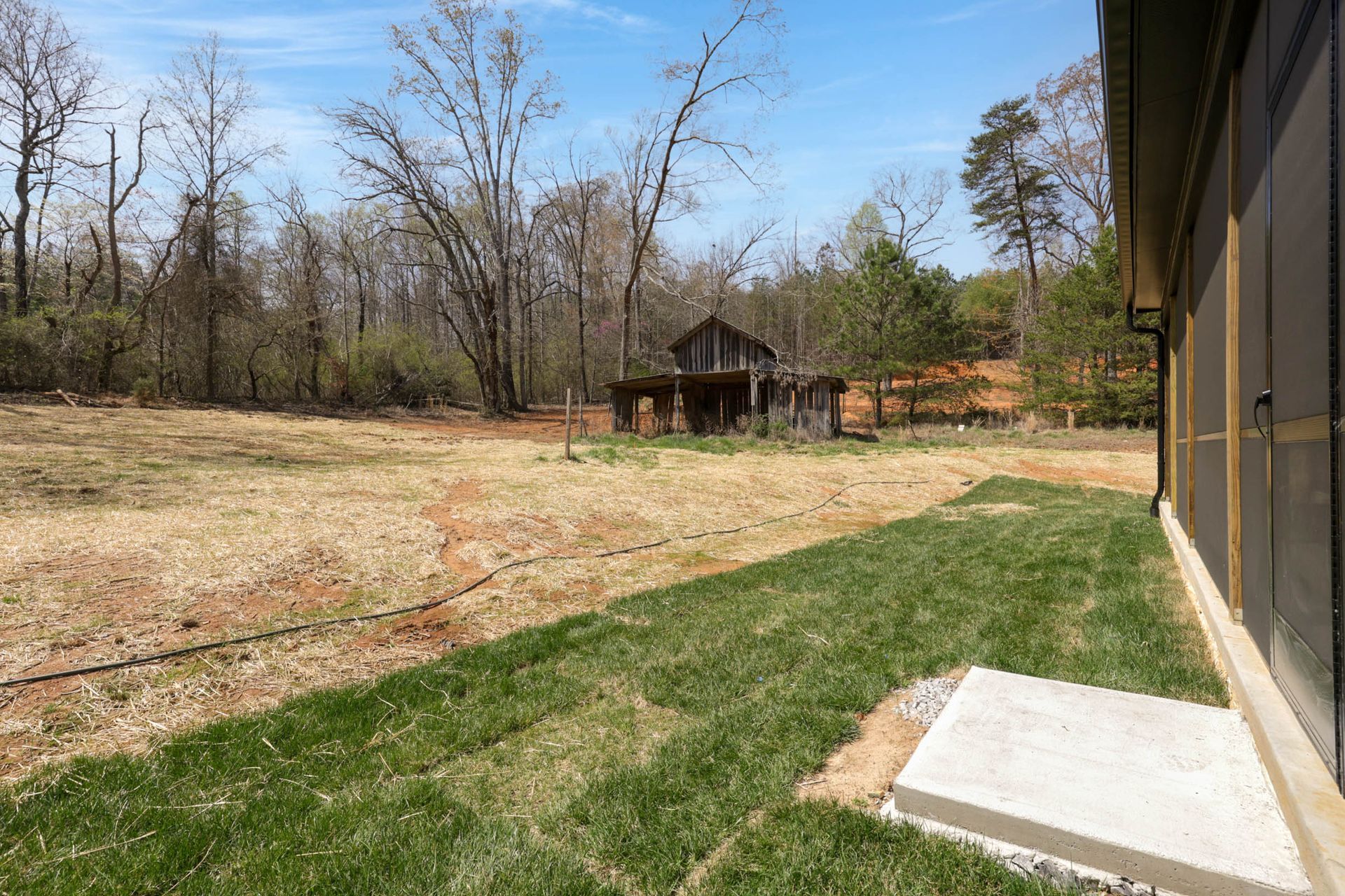 A house is sitting in the middle of a grassy field.