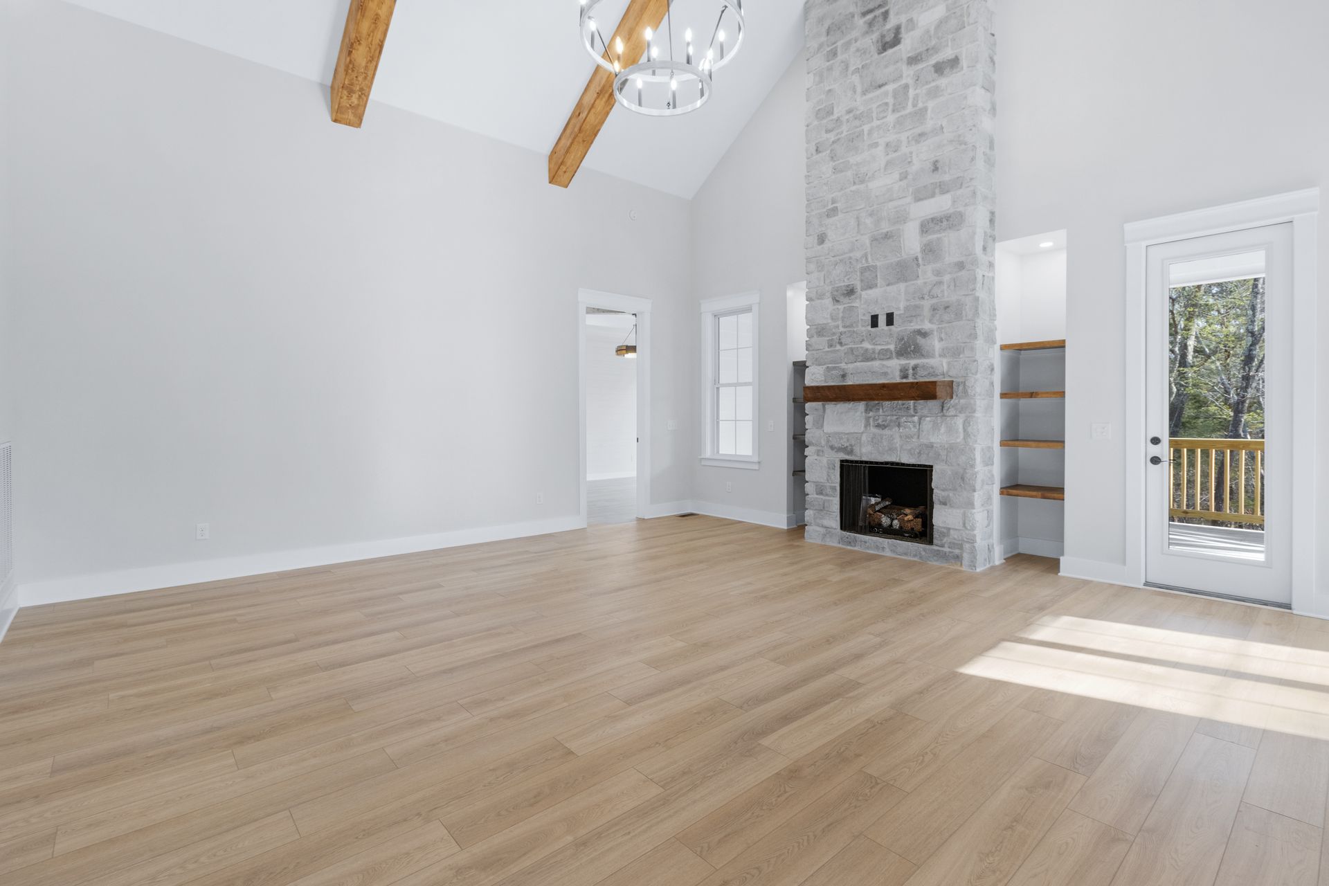 an empty living room with hardwood floors and a fireplace .