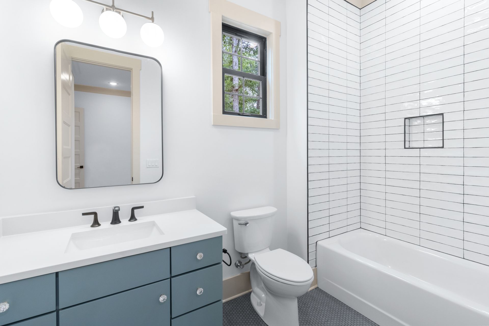 a bathroom with a toilet , sink , mirror and bathtub .