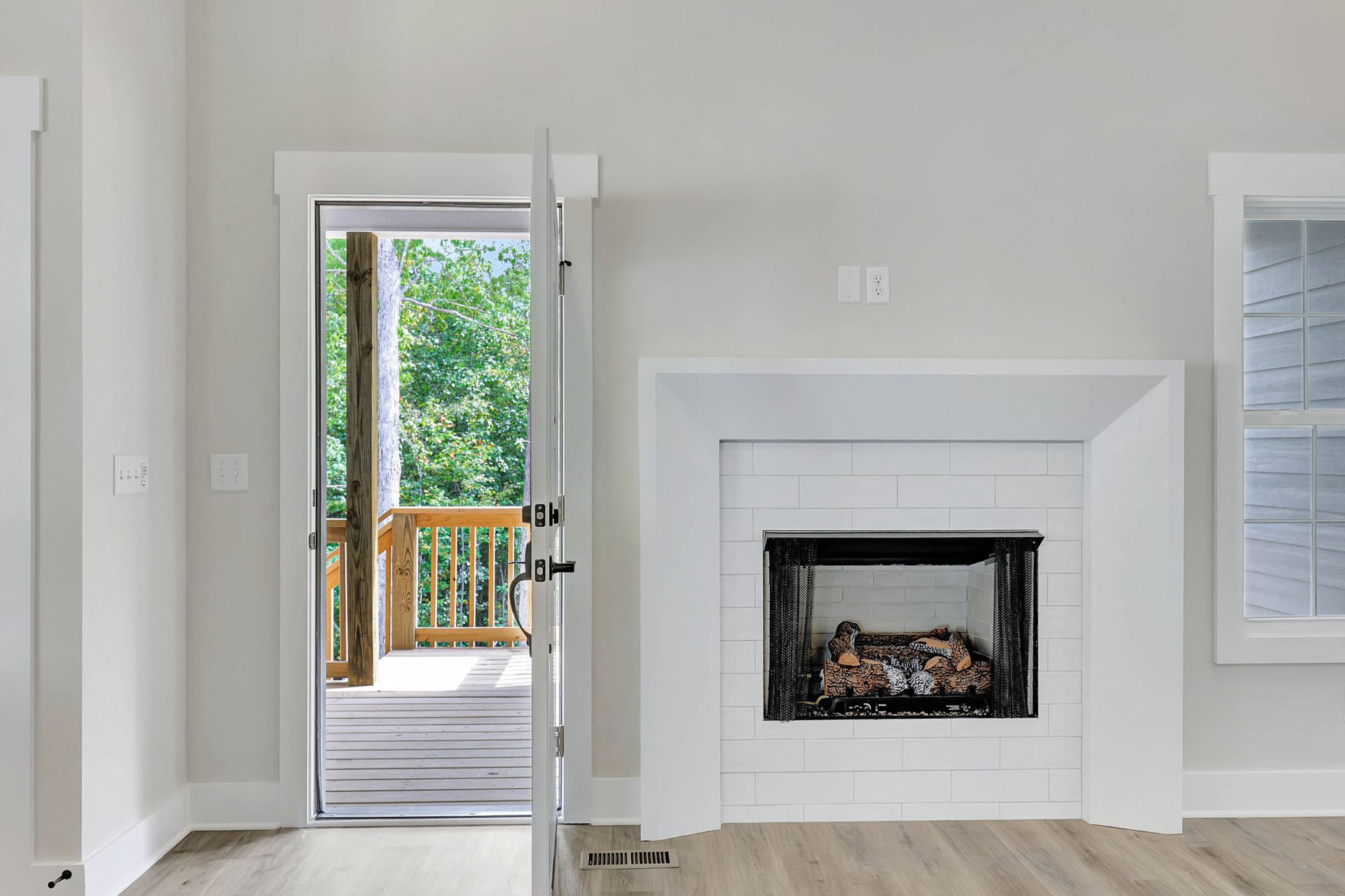 A living room with a fireplace and a door leading to a deck.