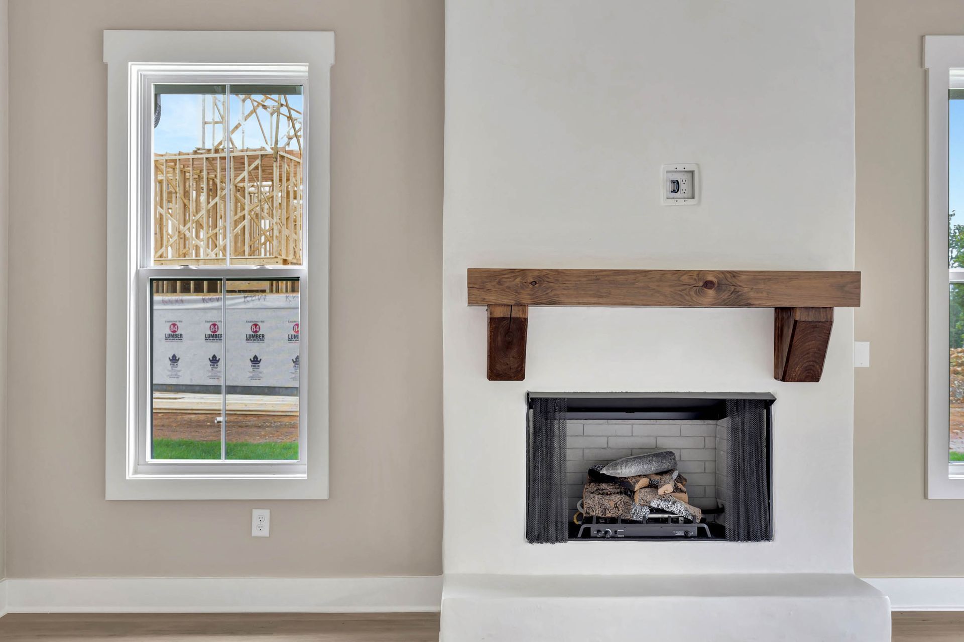 A living room with a fireplace and two windows.