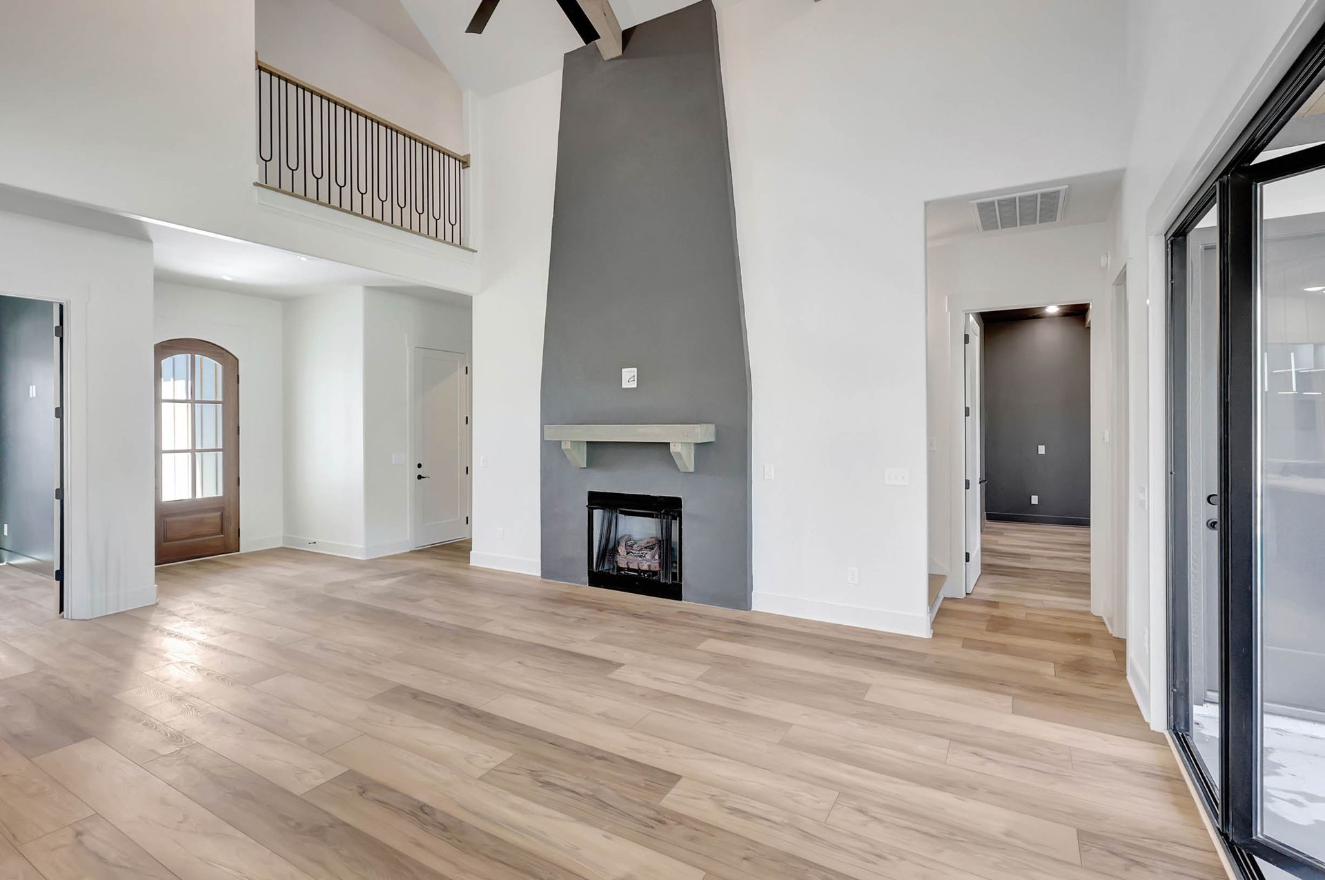 An empty living room with hardwood floors and a fireplace.