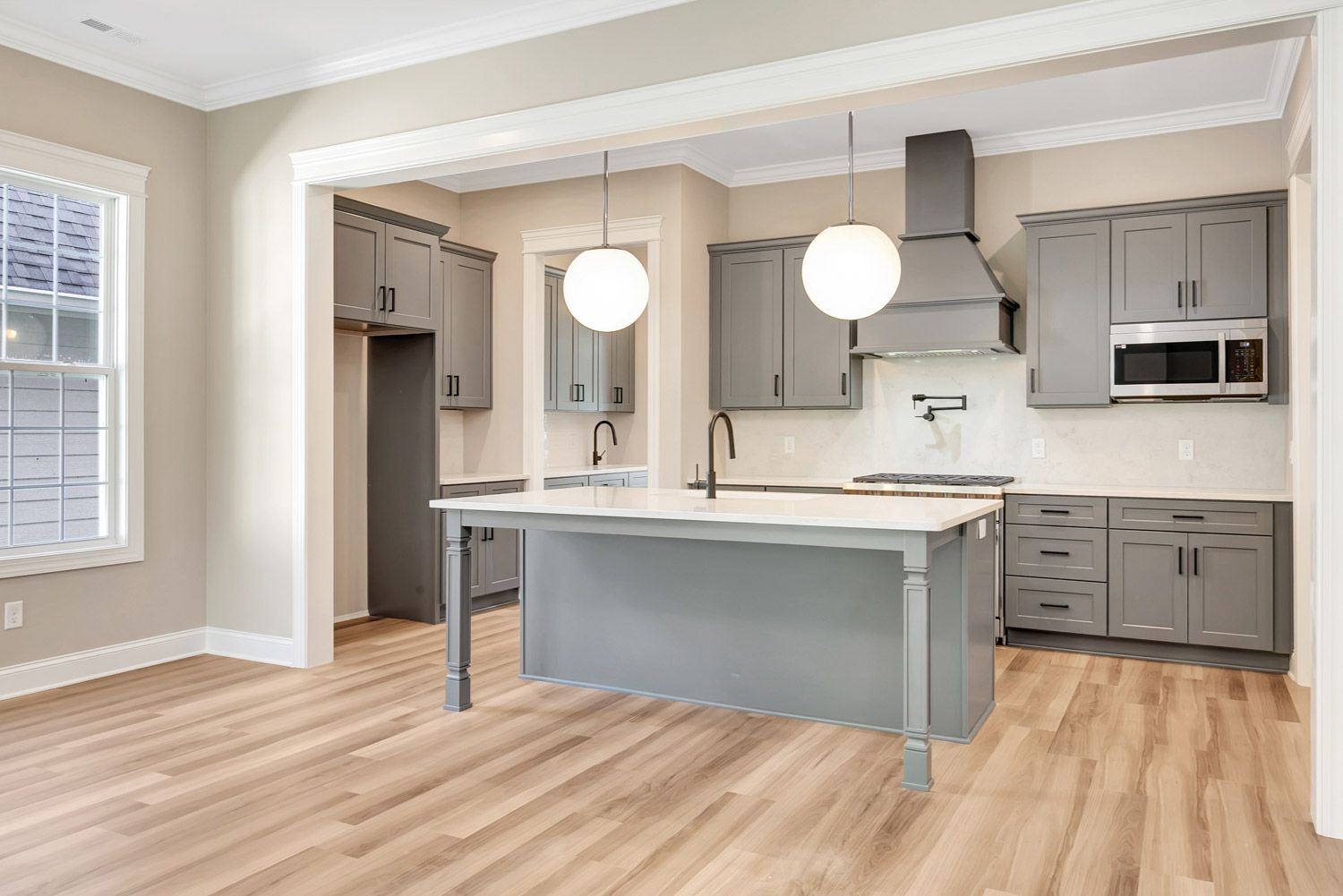 a kitchen with gray cabinets and white counter tops