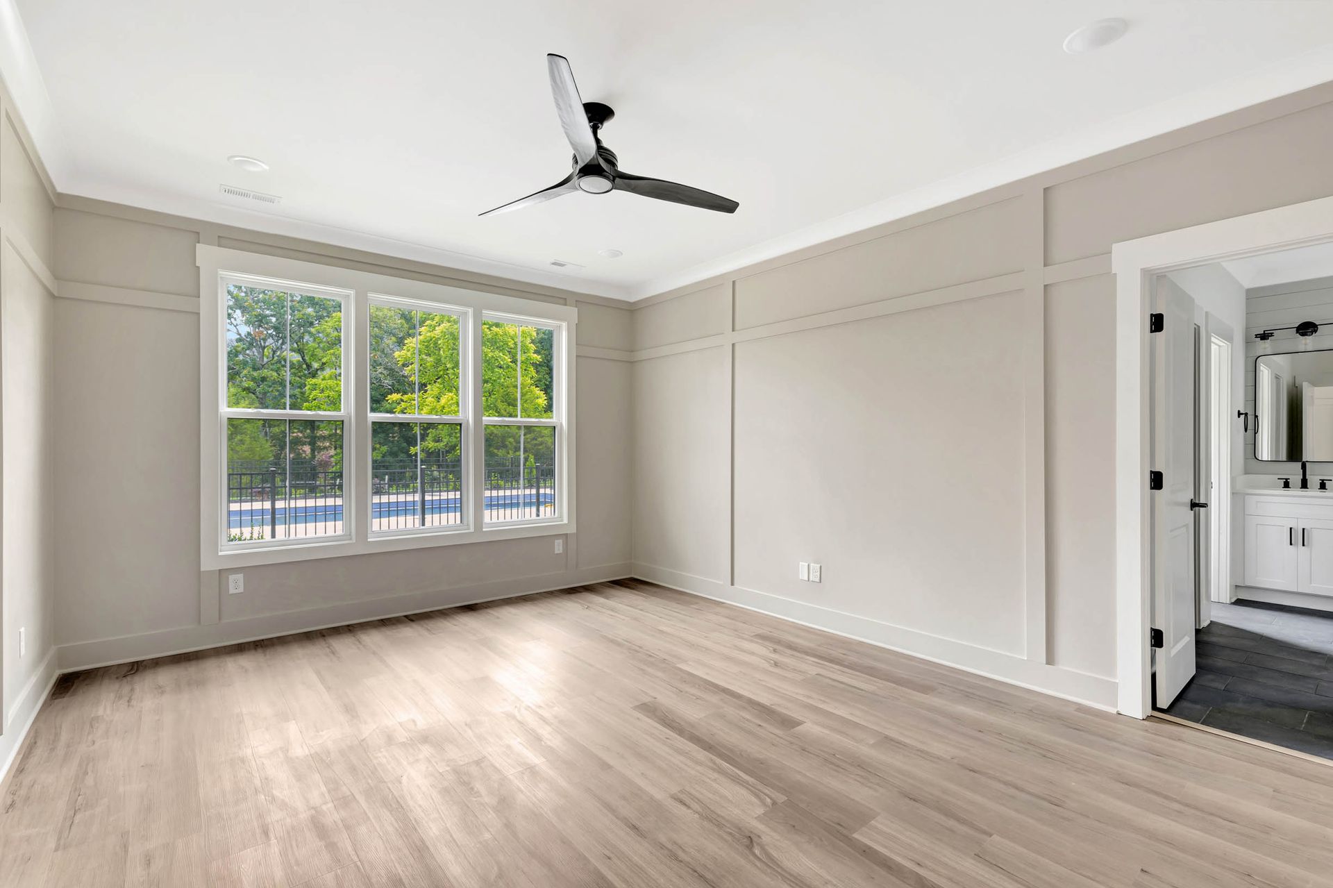An empty living room with hardwood floors and a ceiling fan.