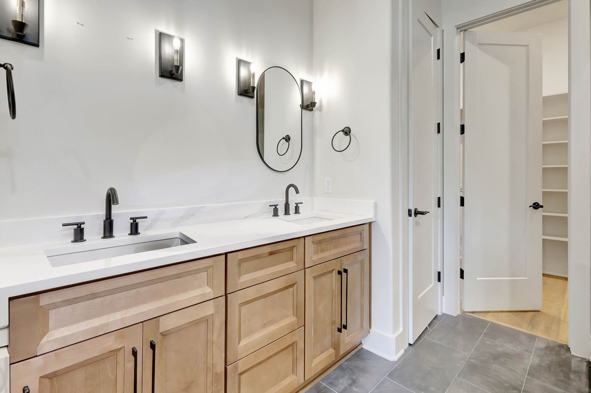 A bathroom with a sink , mirror and cabinets.