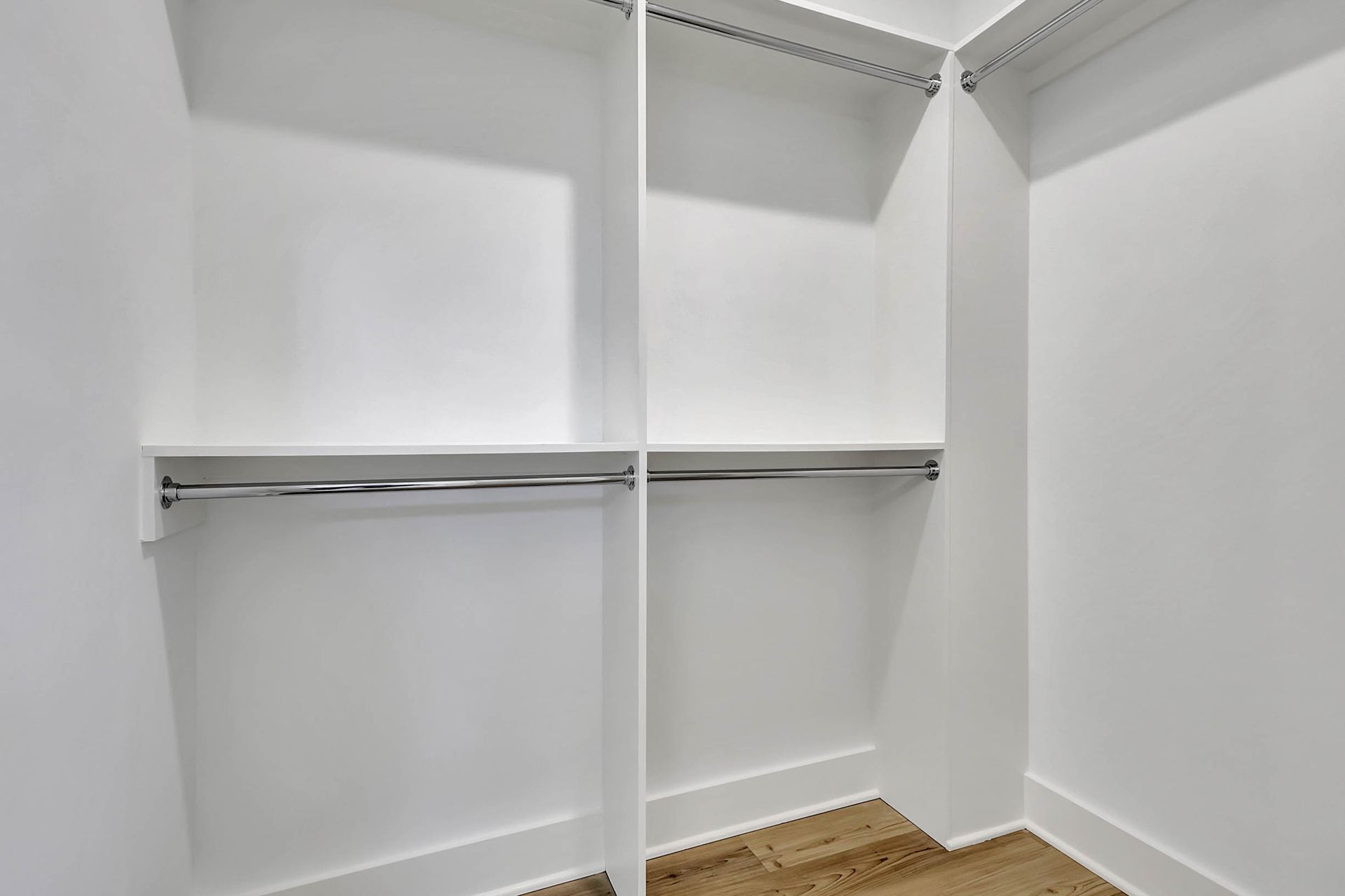 A walk in closet with lots of shelves and clothes racks.