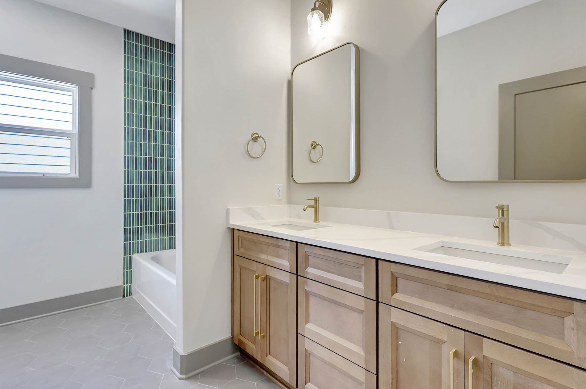 A bathroom with two sinks , a mirror and a tub.