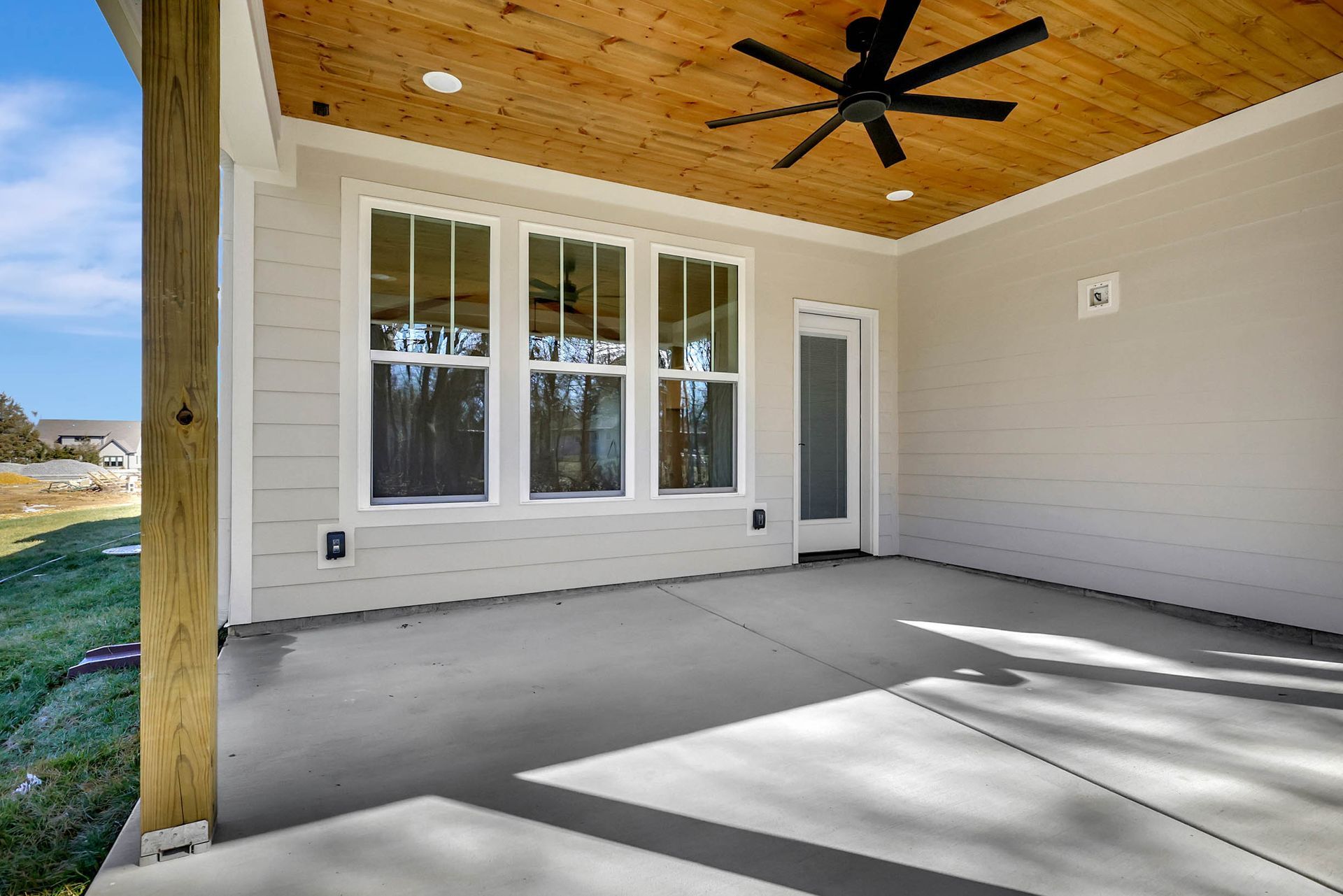 There is a ceiling fan on the porch of a house.