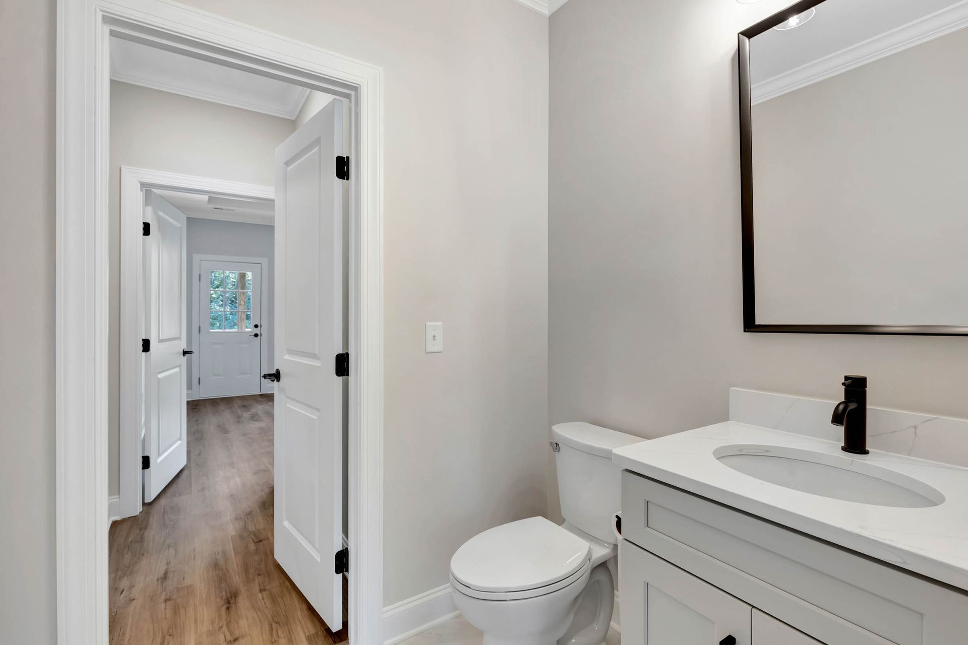 A bathroom with a toilet , sink and mirror.