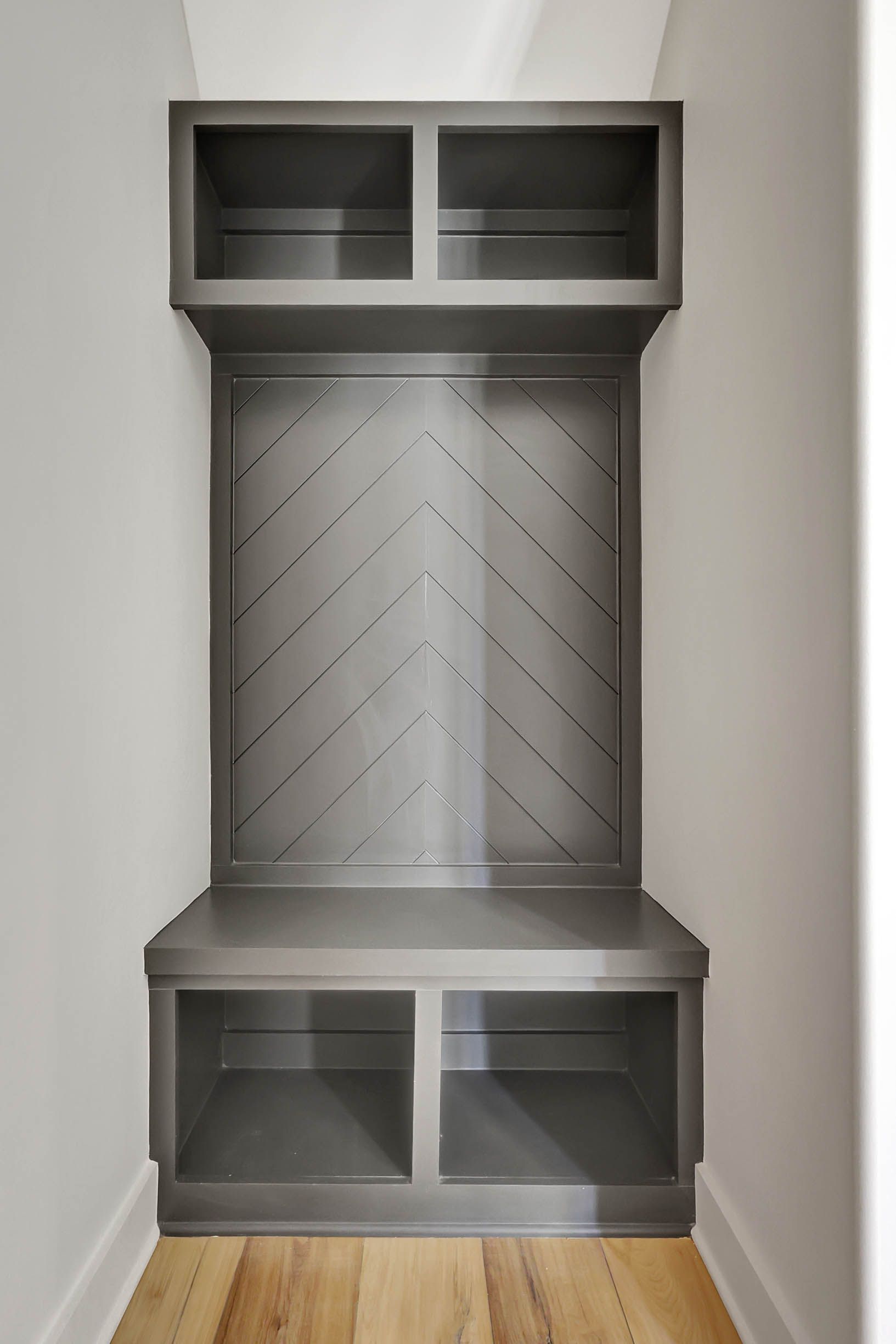 A corner of a room with a bench and shelves.