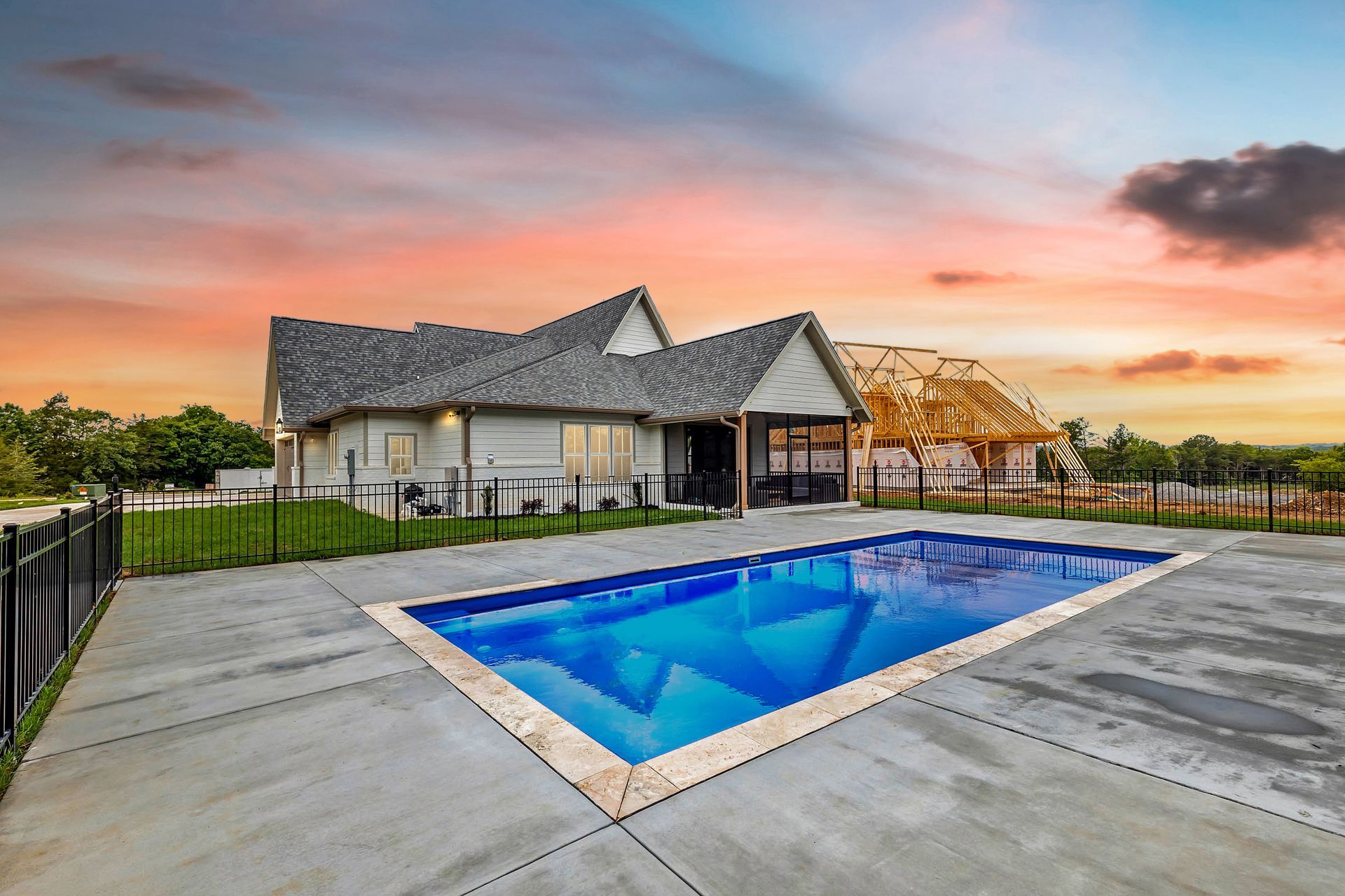 A house with a large swimming pool in front of it.