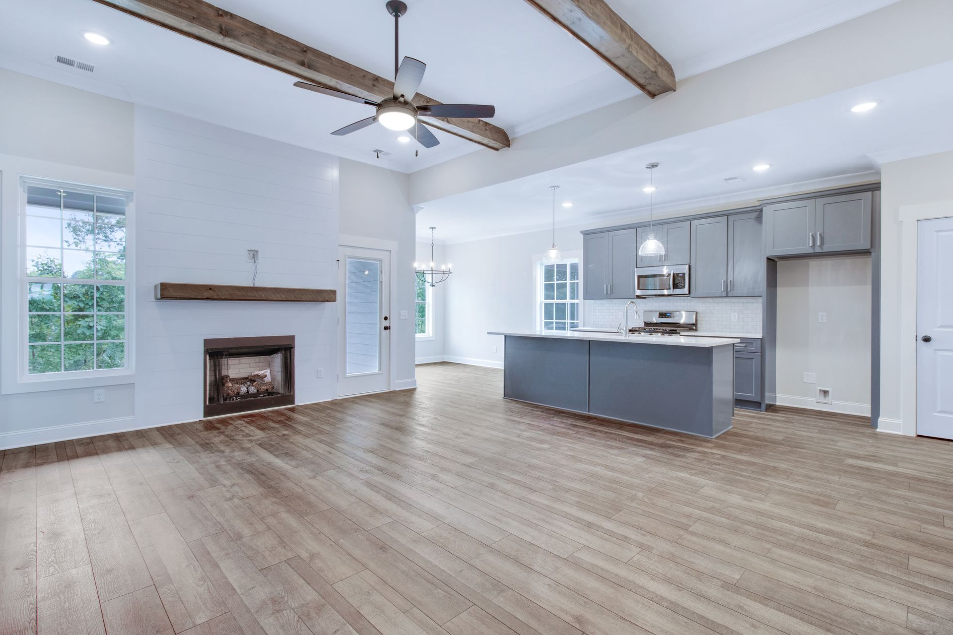 a living room with hardwood floors , a fireplace and a ceiling fan .