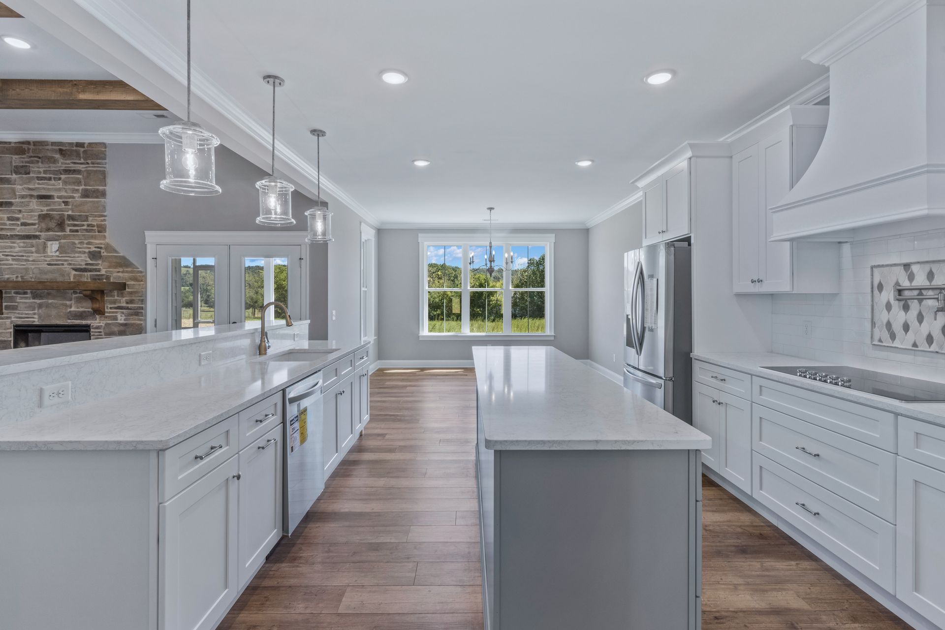 a kitchen with white cabinets and stainless steel appliances and a large island in the middle .