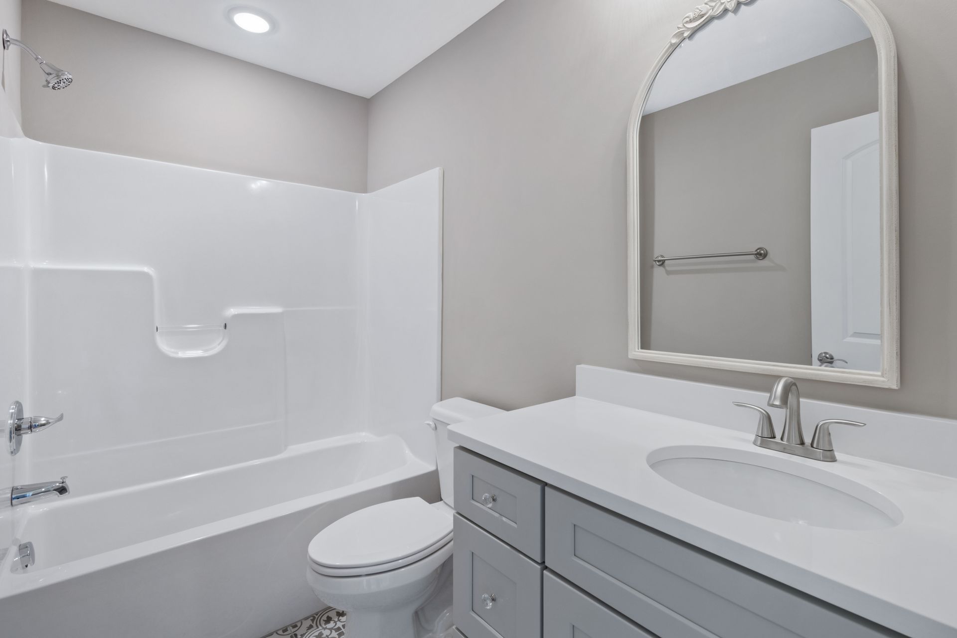 a bathroom with a toilet , sink , bathtub and mirror .