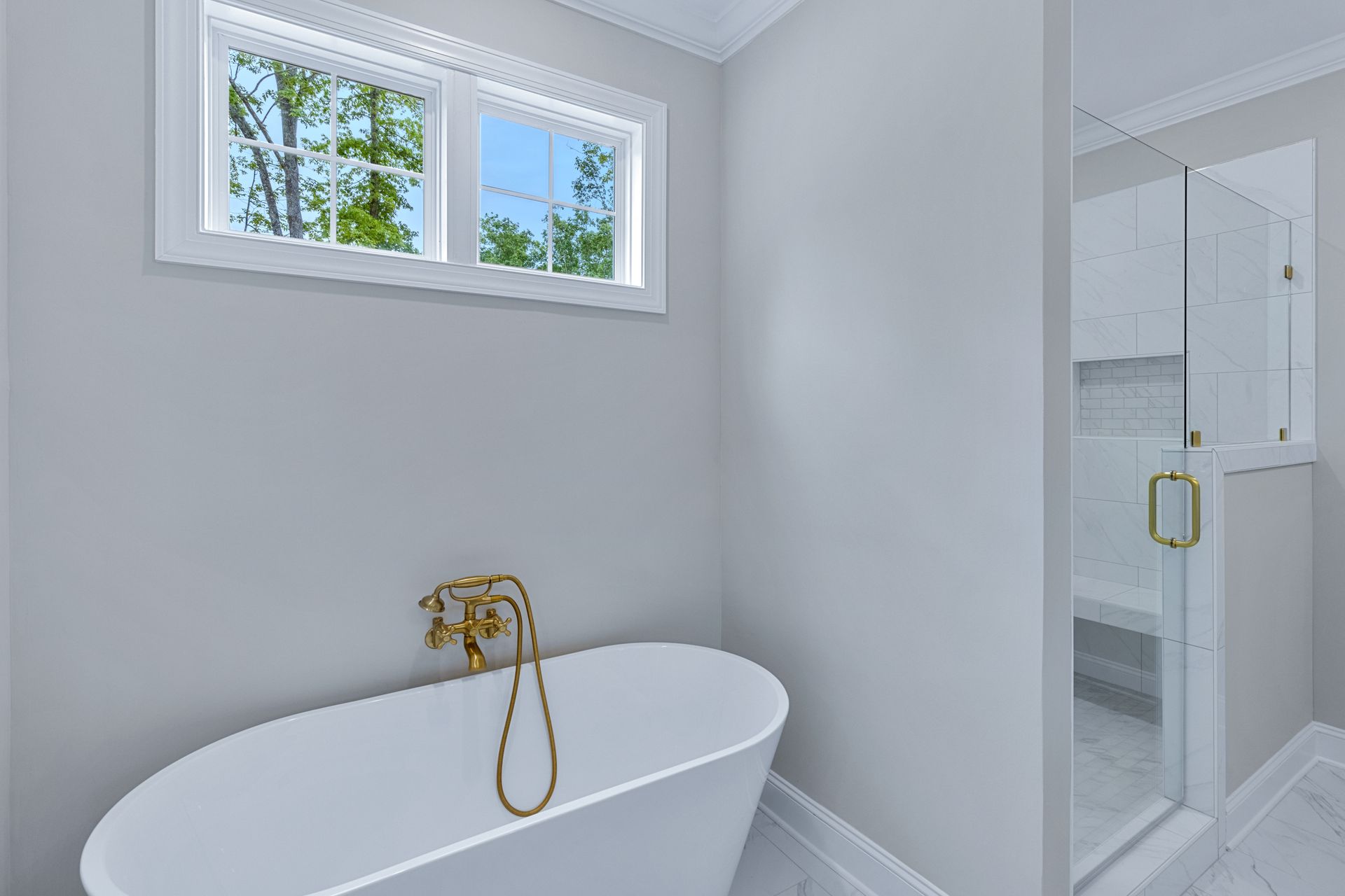 a bathroom with a bathtub , shower , and window .