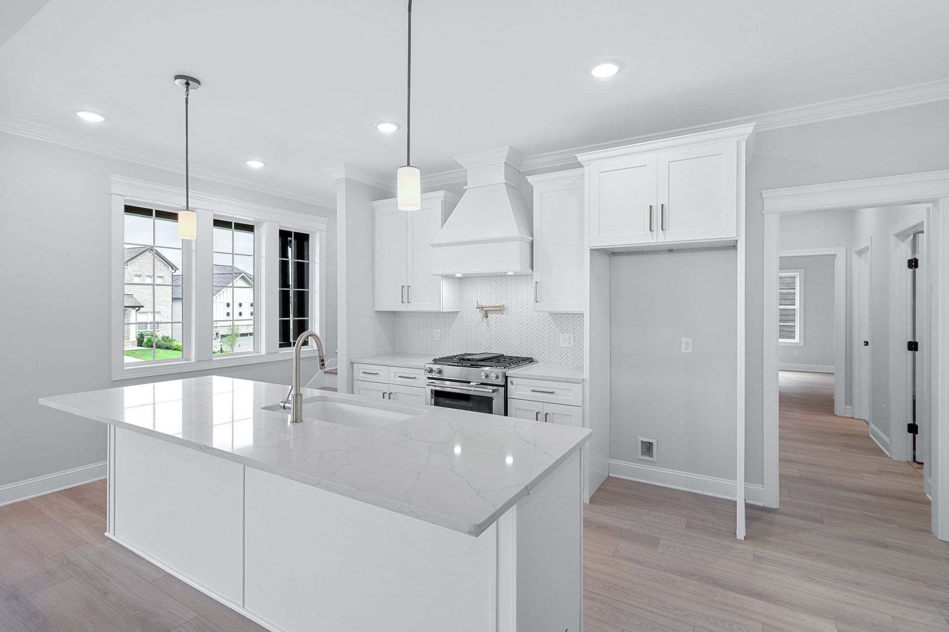 a kitchen in a new home with white cabinets and a large island .