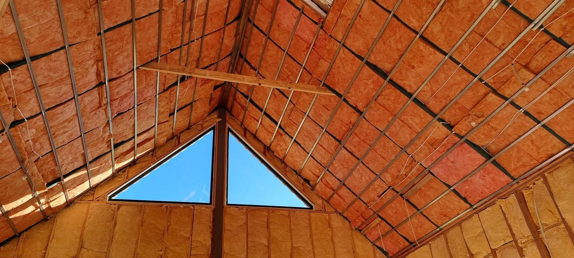 Interior of a brick dome roof with a triangular skylight showing blue sky