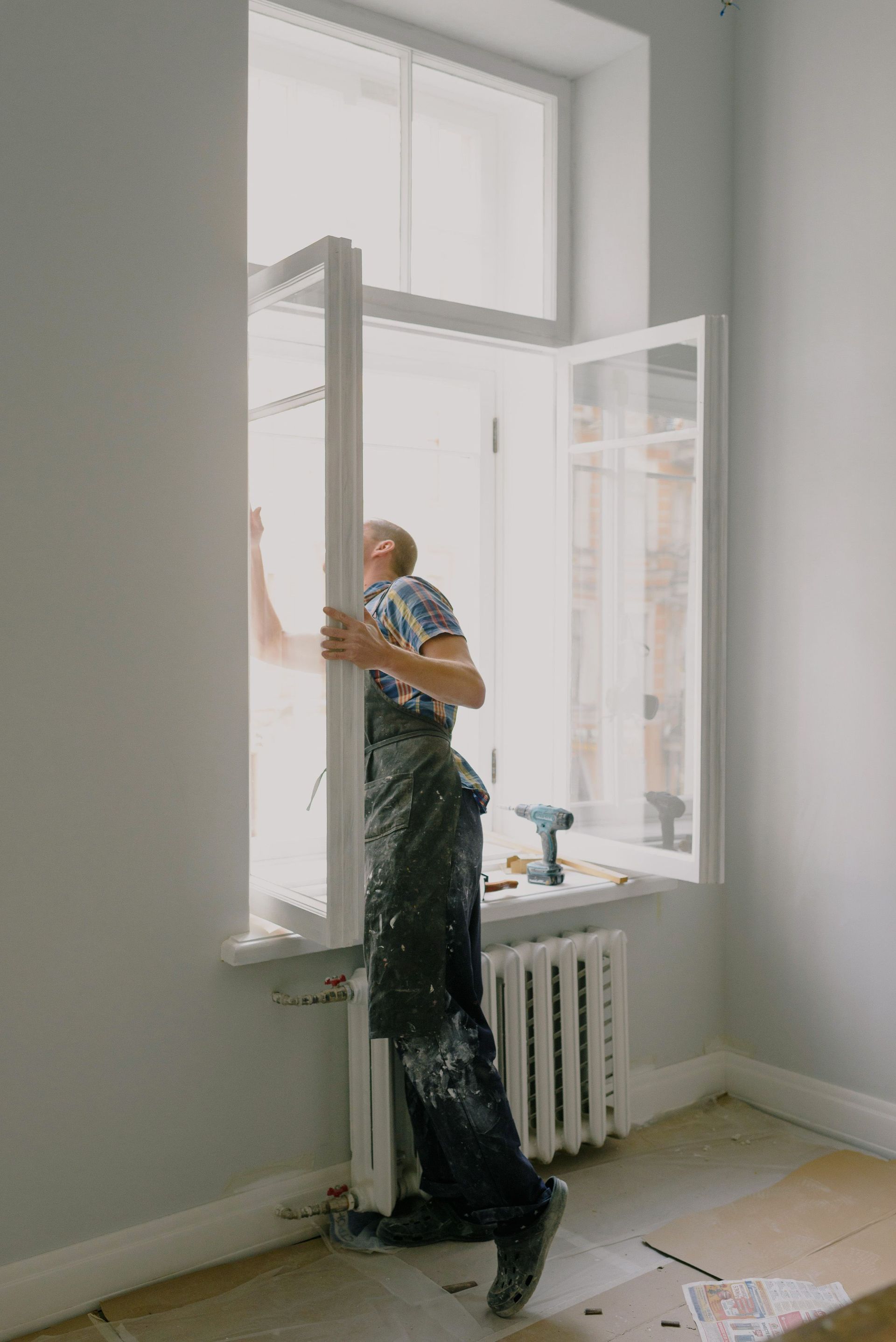 worker installing a new window sash in a home
