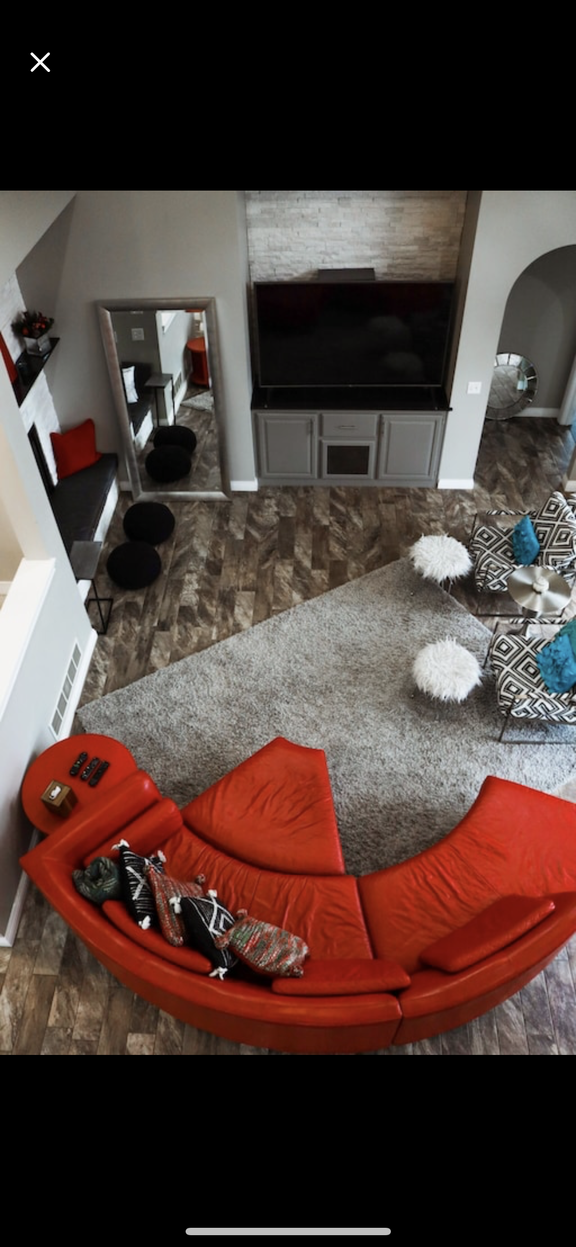 An aerial view of a living room with a curved red couch.
