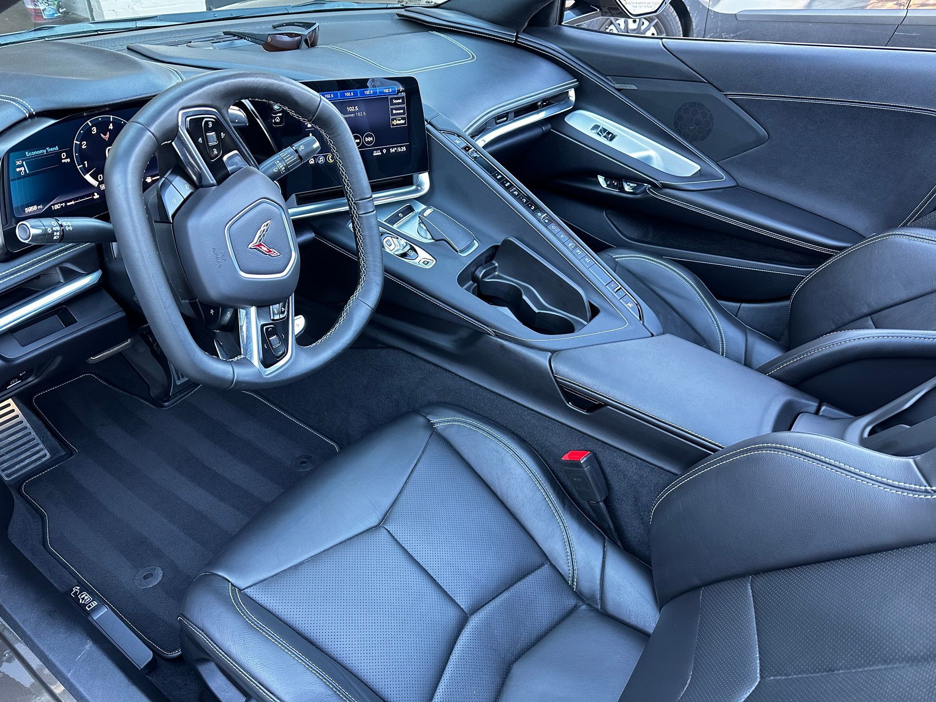 Black leather interior of a Corvette sports car, including seats, dashboard, and steering wheel.