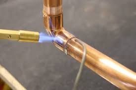 Comfort Air Solution LLC - A man is fixing an air conditioner with a screwdriver.
