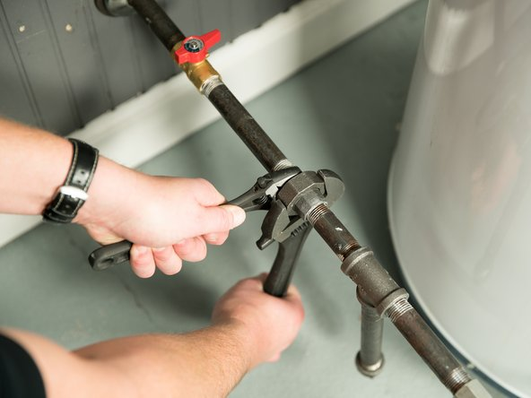 Comfort Air Solution LLC - A man is fixing an air conditioner with a screwdriver.