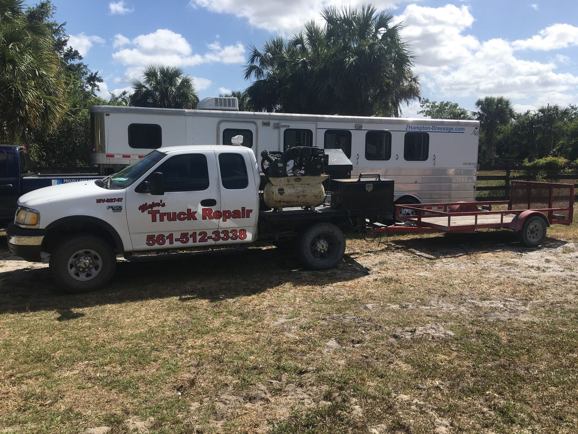A truck that says truck repair is parked next to a trailer